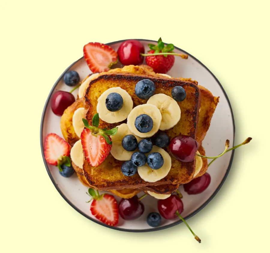 Tostada francesa con banano, arándanos, fresas y cerezas